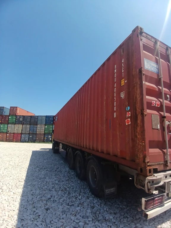 Container 40 pieds High Cube d’occasion rouge vu de trois-quarts arrière sur remorque